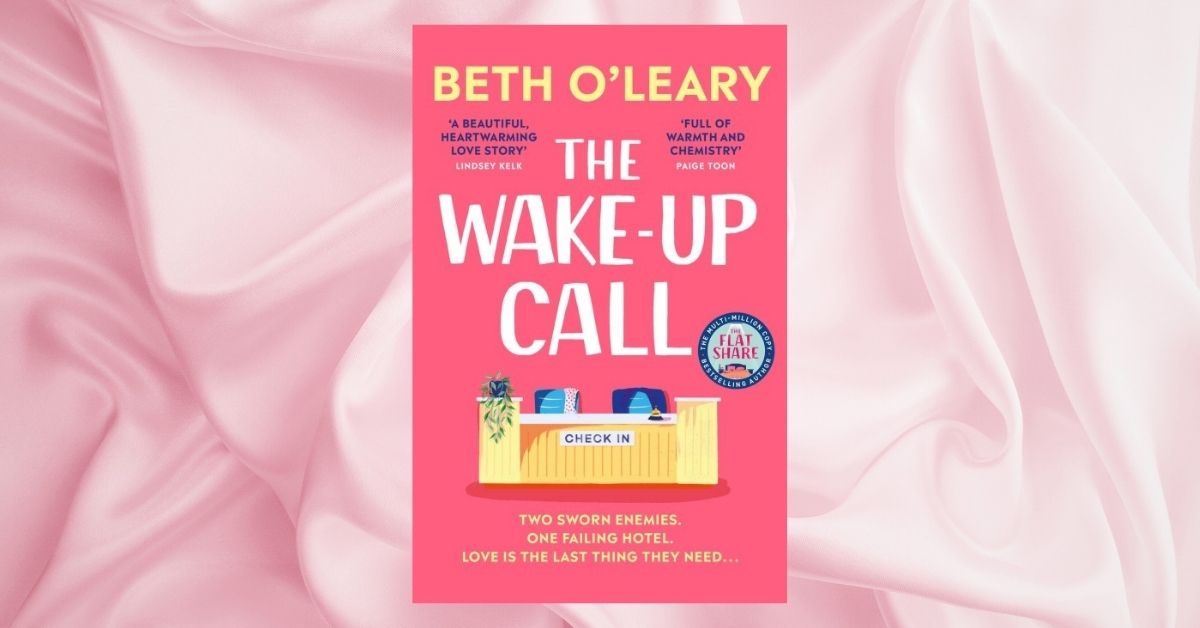 Book cover for "The Wake-Up Call" by Beth O'Leary, set against background of pink silk