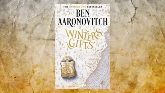 The book cover of Winter's Gifts by Ben Aaronovitch set against a background of crumpled parchment
